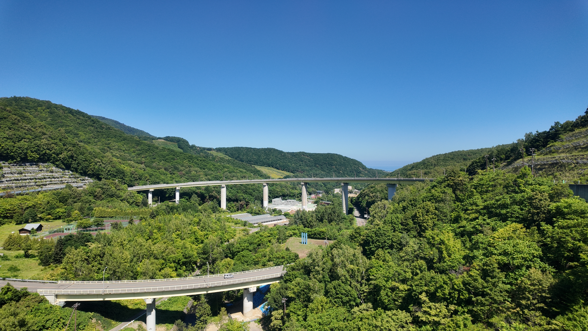 小樽市の朝里スカイループと緑の山に囲まれた道路