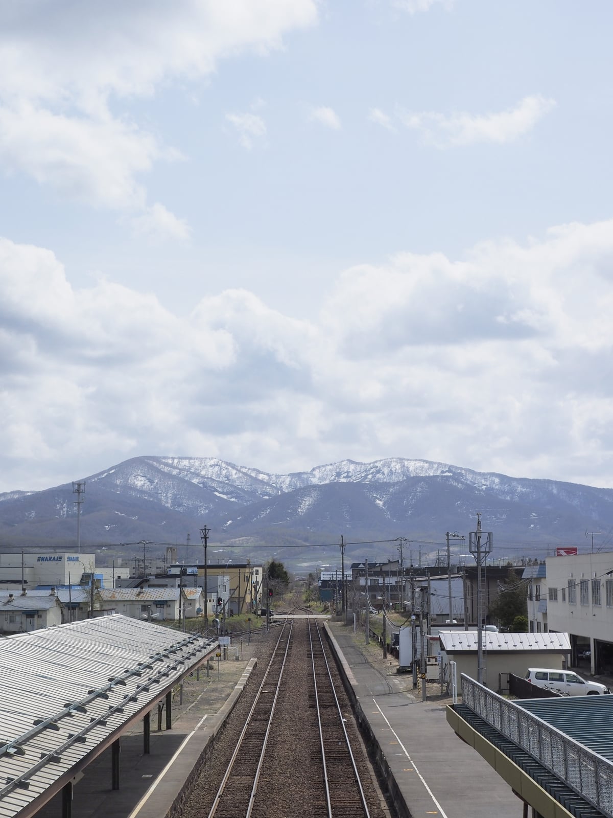 余市駅付近の線路と遠くの山並み
