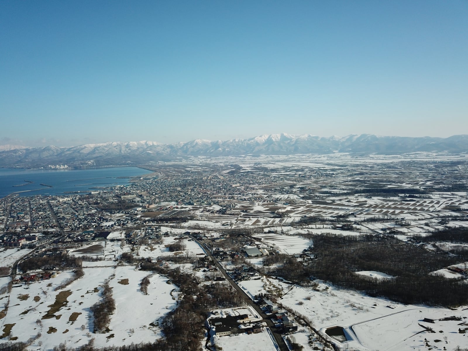 雪に覆われた岩内町の市街地と海